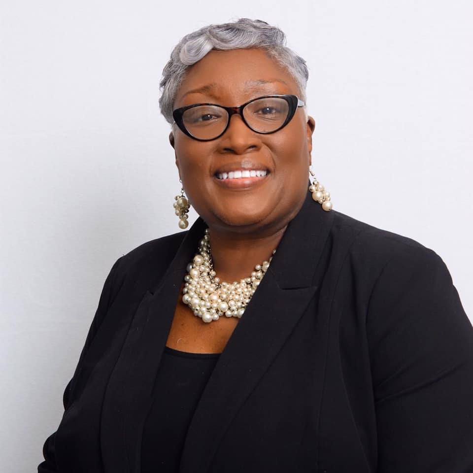 Women with gray hair and a big pearl necklace with a black jacket